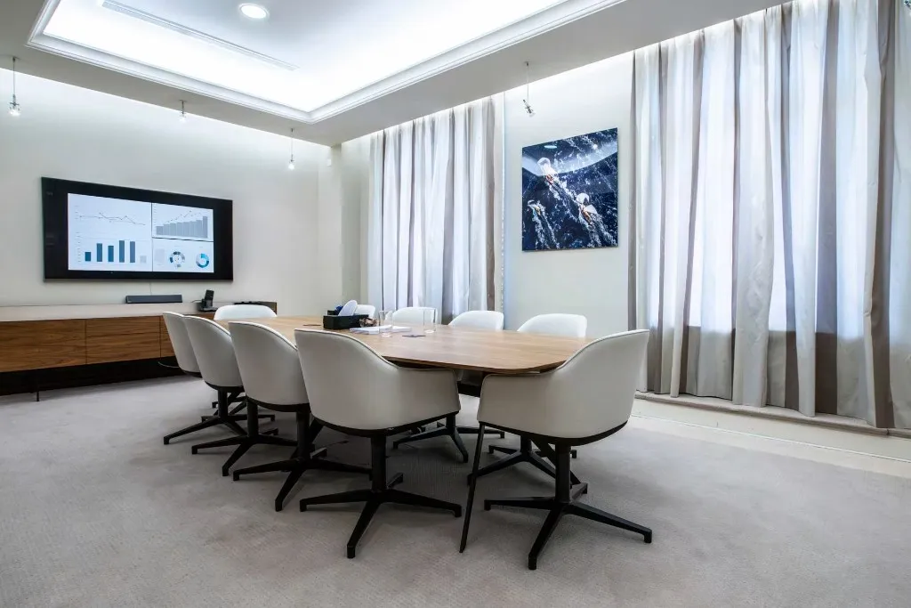Modern conference room with financial charts on a large display