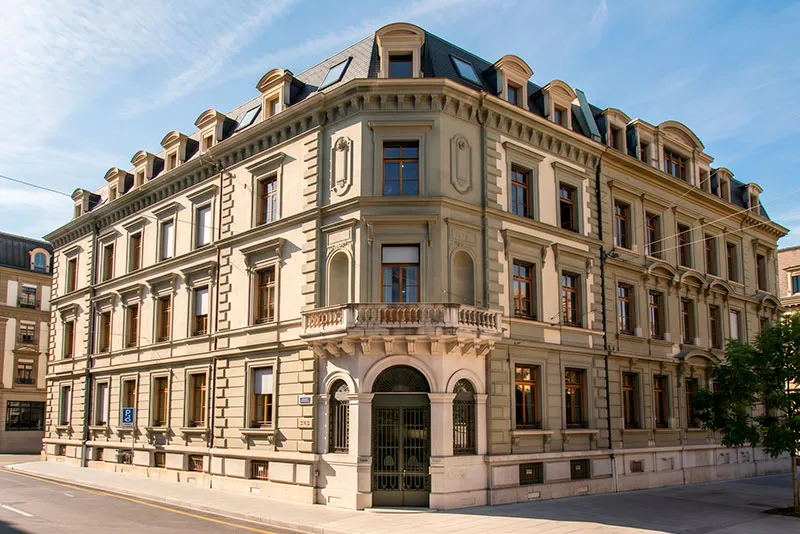 Classical stone building with green trim at a street corner